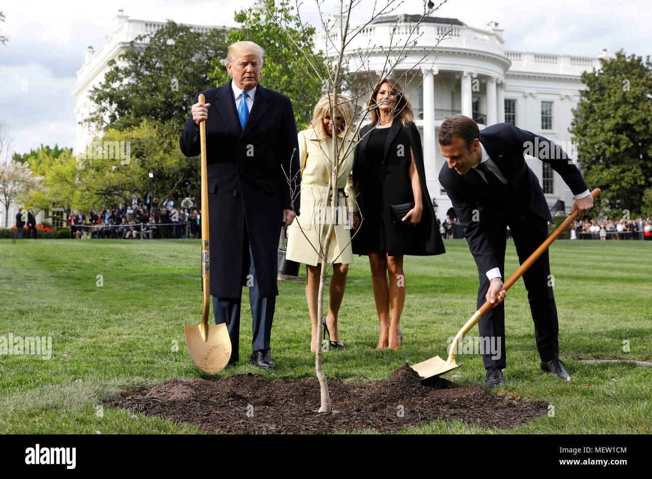 U.S. President Donald Trump with France's president Emmanuel Macron and First Ladies Melania Trump and Brigitte Macron plant a tree, a gift from the President and Mrs. Macron, on the South Lawn of the White House in Washington, DC, U.S., on Monday, April 23, 2018. As Macron arrives for the first state visit of Trump's presidency, the U.S. leader is threatening to upend the global trading system with tariffs on China, maybe Europe too. Credit: Yuri Gripas/Pool via CNP /MediaPunch Stock Photo