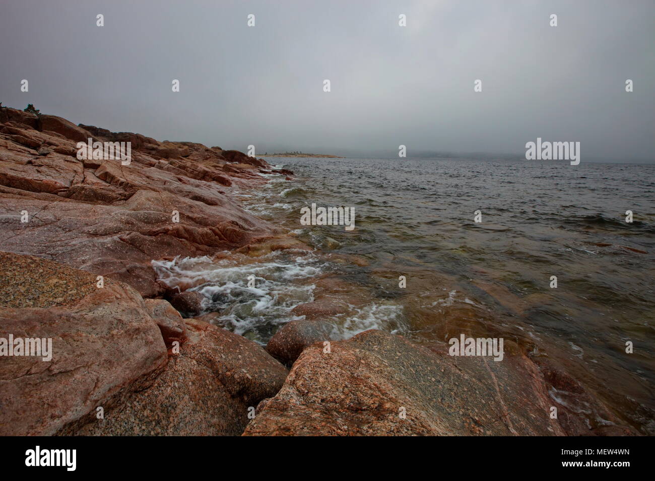 Red granite rock ocean shore of the Baltic Sea in Sweden Stock Photo