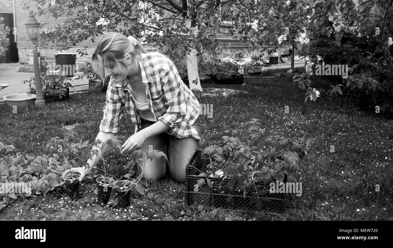 Black and white photo of young woman gardening at backyard Stock Photo
