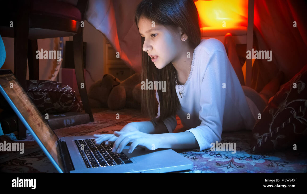 Portrait of cute girl with laptop lying on floor at night Stock Photo ...