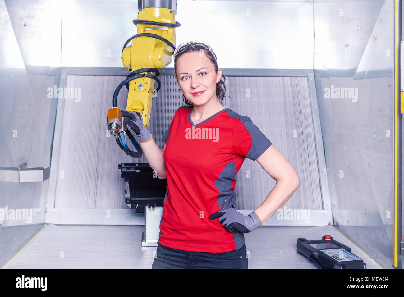 A young female technician while machine constructing in a manufacturing plant Stock Photo