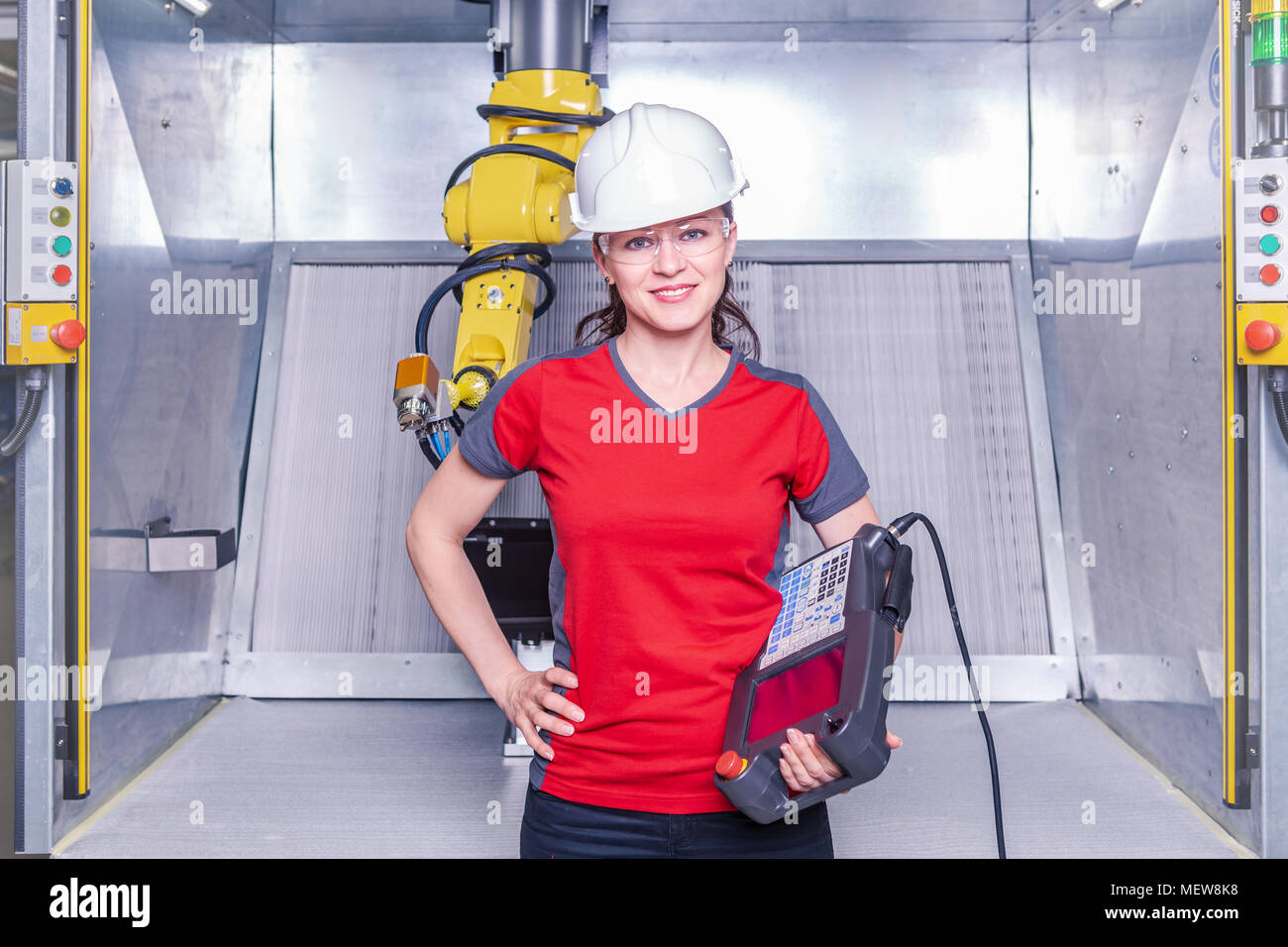 A young female technician while machine constructing in a manufacturing plant Stock Photo