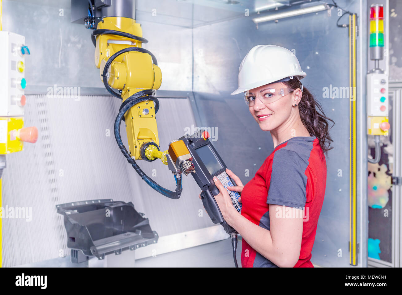 A young female technician while machine constructing in a manufacturing plant Stock Photo