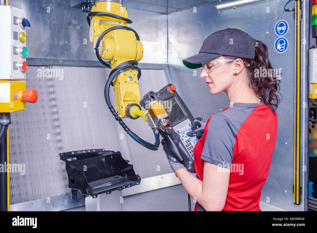 A young female technician while machine constructing in a manufacturing plant Stock Photo