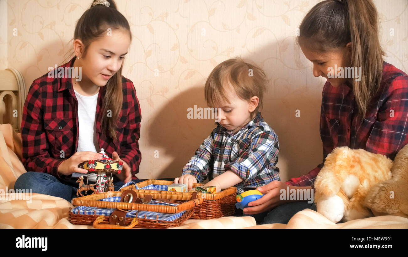 Cute little boy playing with toys on bed at bedroom Stock Photo