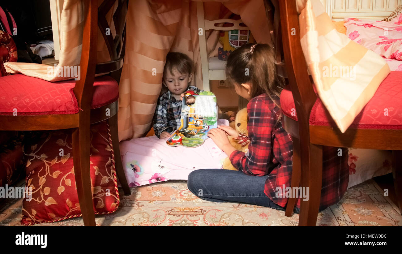Cute Toddler Boy Reading Book In Tepee Tent In Bedroom Stock