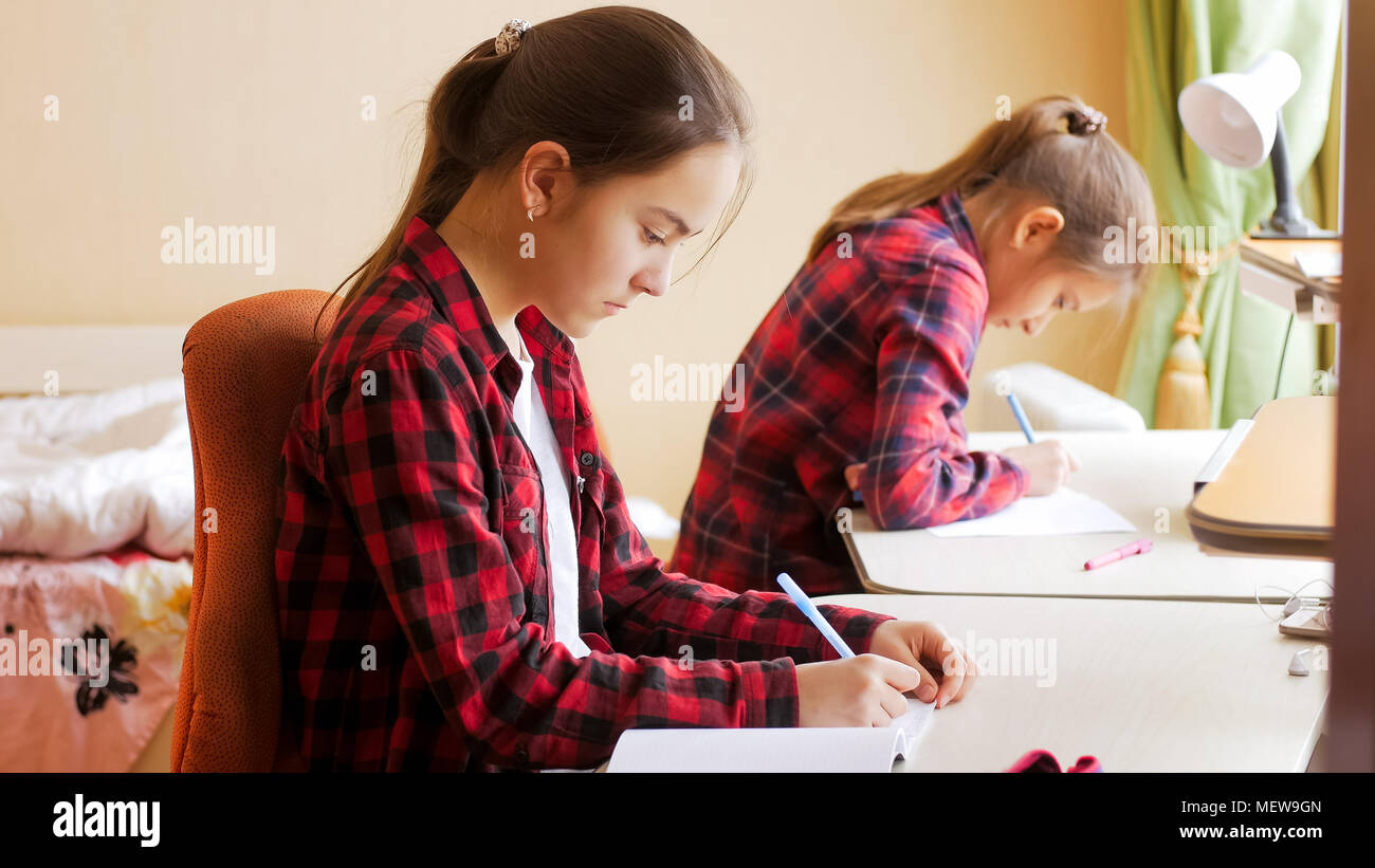 Portrait of two teenage girls doing homework at home Stock Photo - Alamy