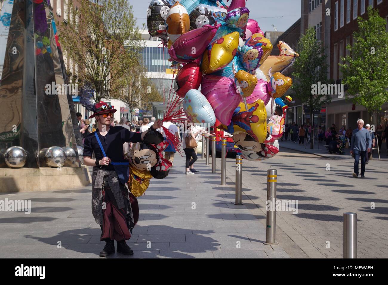 Balloon Seller on Exeter High Street, with the Exeter Riddle Obelisk