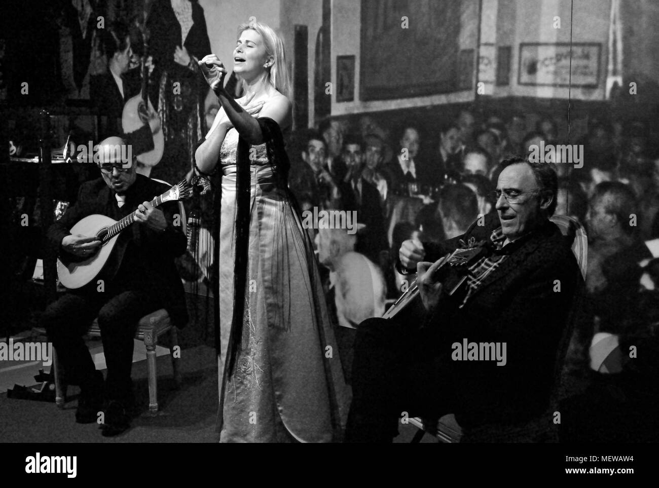 Black and white image with Fado singer and two musicians playing classical guitar and portuguese guitar Stock Photo