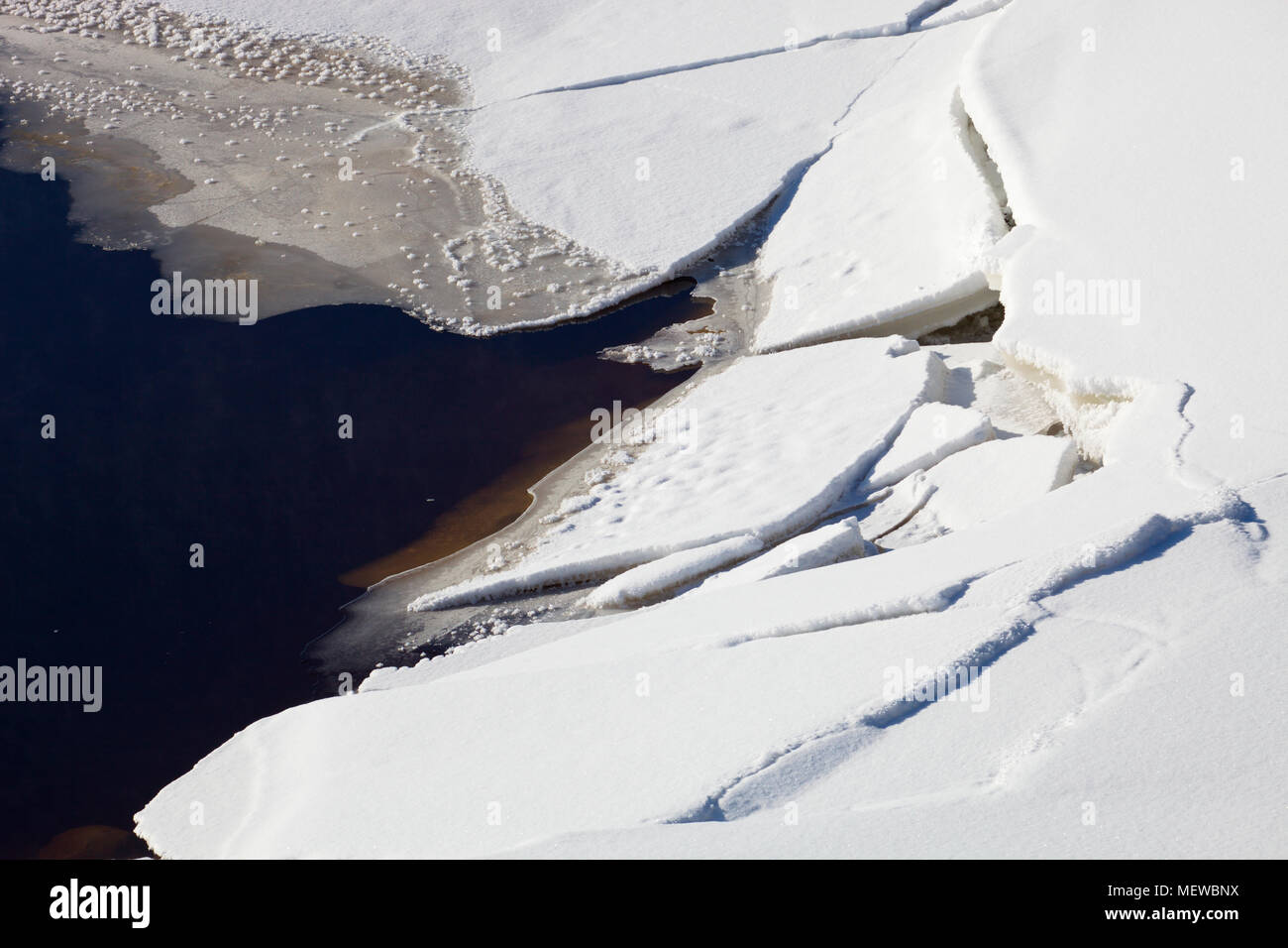 Ice  covering a lake has cracked. Stock Photo