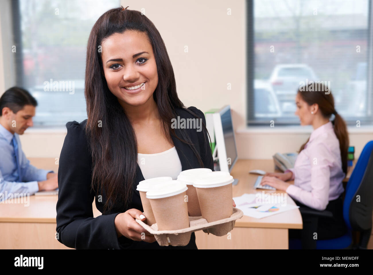 Female Intern Fetching Coffee In Office Stock Photo