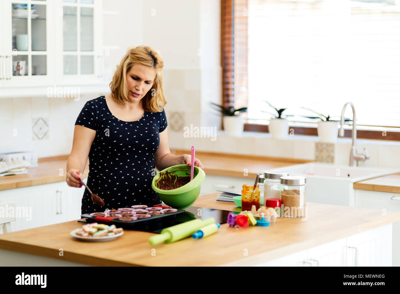 Beautiful pregnant woman baking muffins Stock Photo Alamy