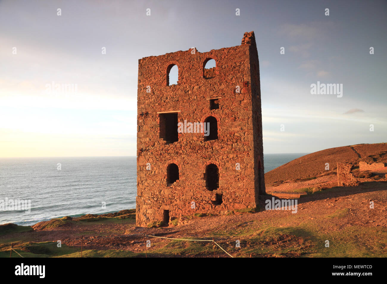 The ruins of the Towanroath engine house, St Agnes, Cornwall, are illuminated by the setting sun. Stock Photo