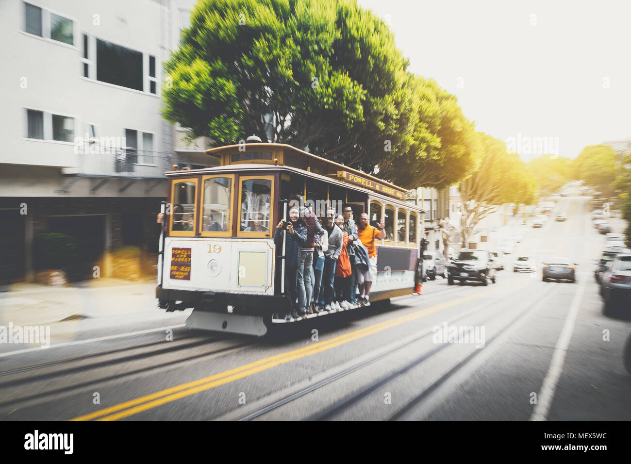 Classic view of traditional San Francisco cable car on Powell-Hyde Street line with motion blur and lens flare effect at sunset, San Francisco, USA Stock Photo