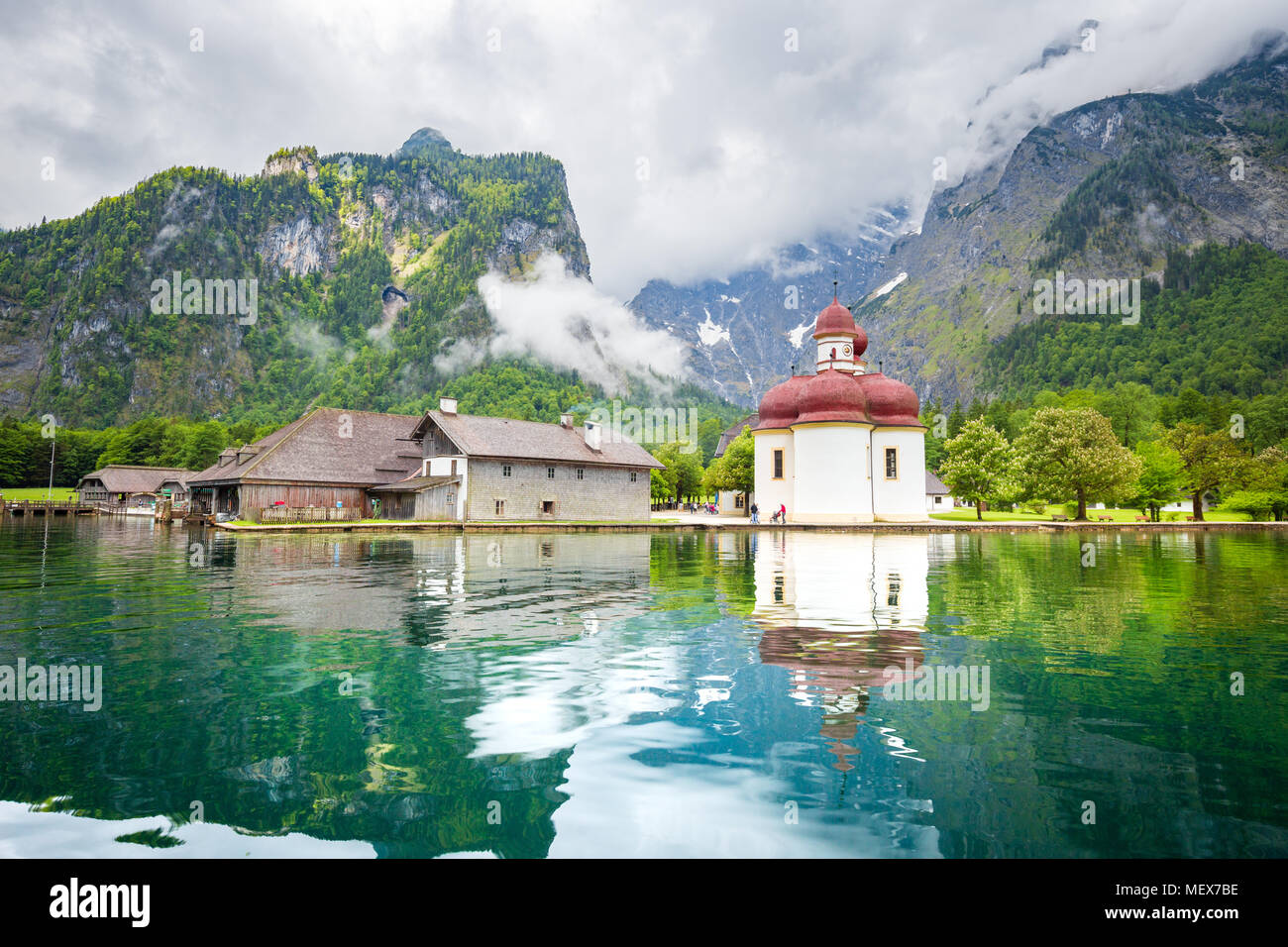 Classic panoramic view of Lake Konigssee with world famous Sankt Bartholomae pilgrimage church and Watzmann mountain on a beautiful day in summer Stock Photo