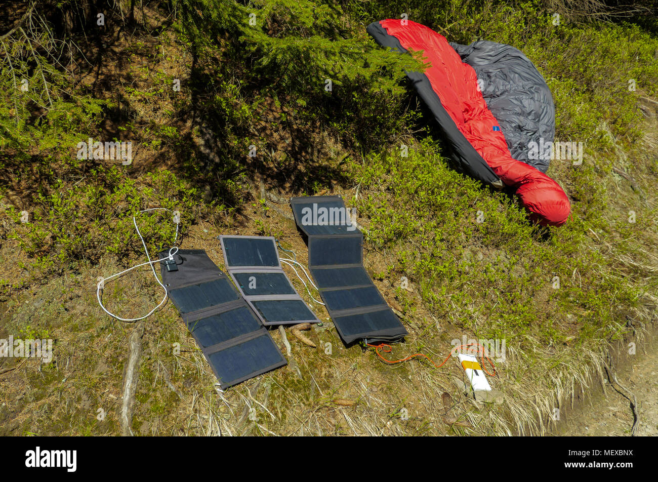 three portable solar panels recharging a batteries from a sun, outdoors