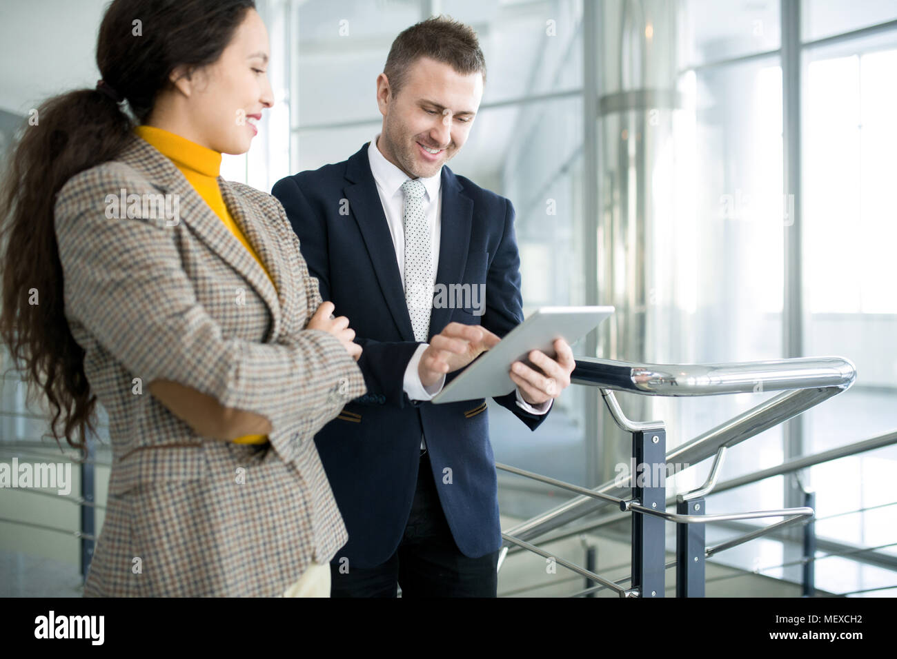 Positive businessman with assistant using tablet Stock Photo