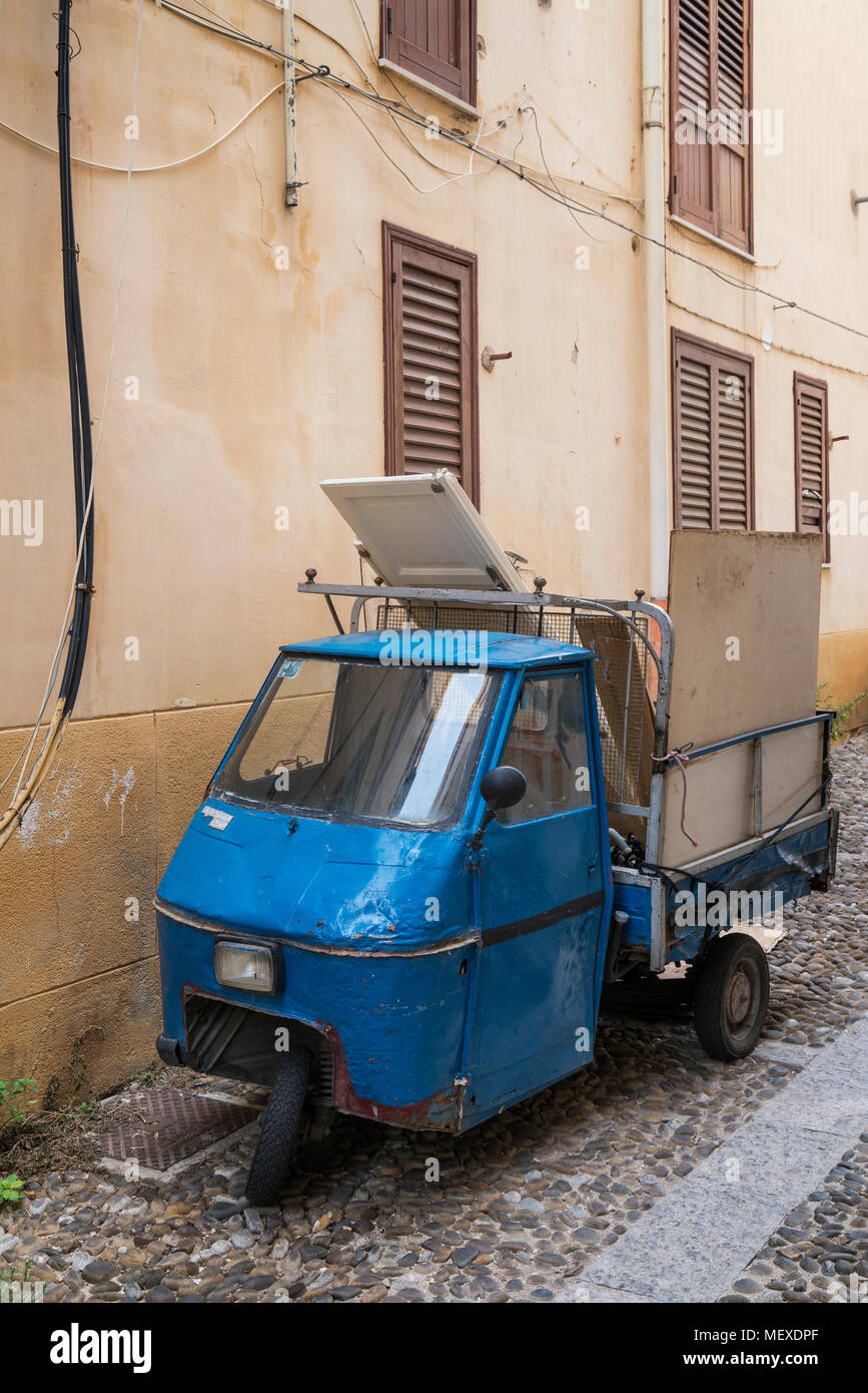 An old Piaggio Ape with lots of body repairs down a back street in Palermo, Sicily, Italy Stock Photo