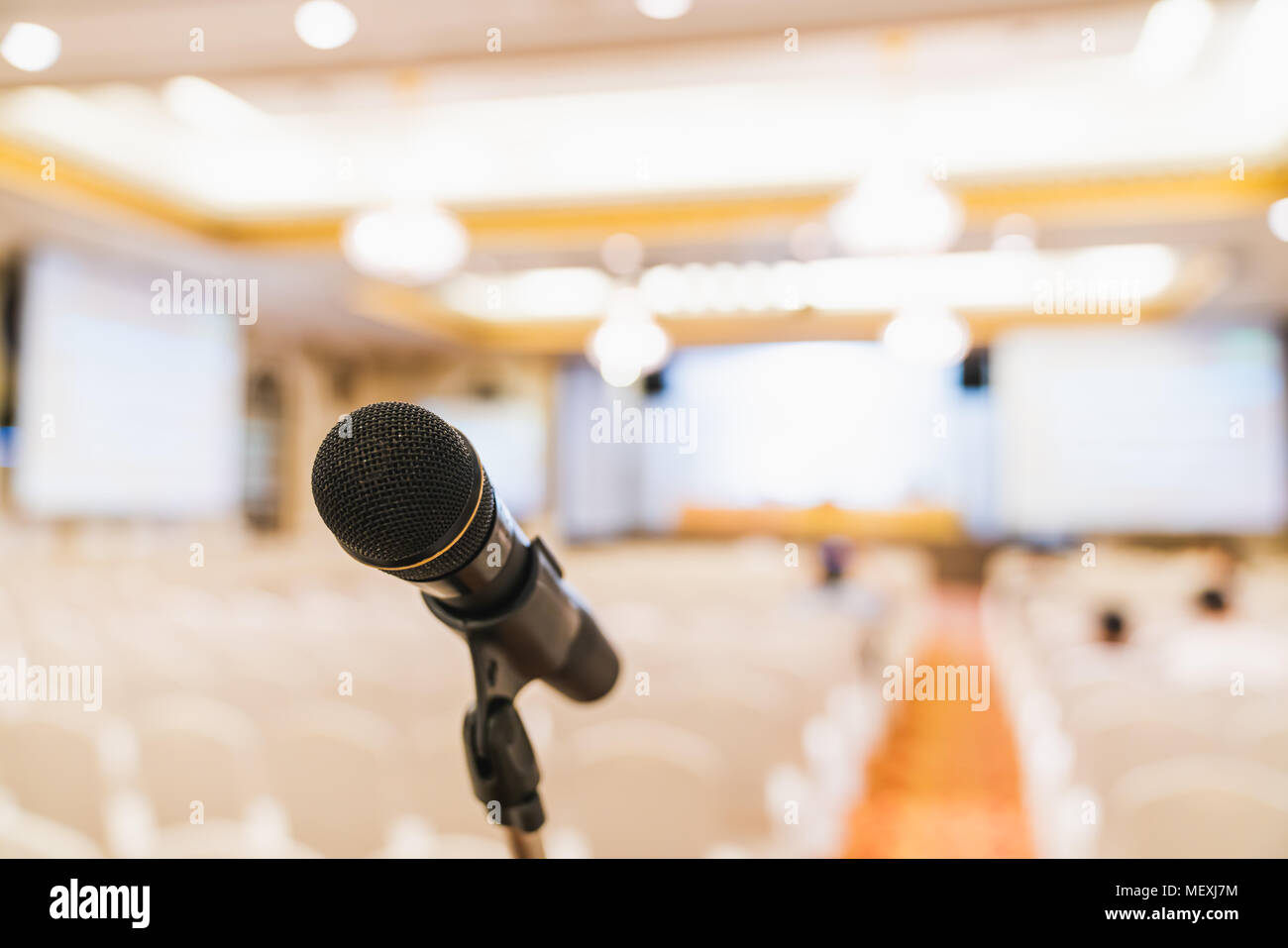 Microphone stand in conference hall blurred background with copy space. Public announcement event, Organization company meeting, live performance Stock Photo