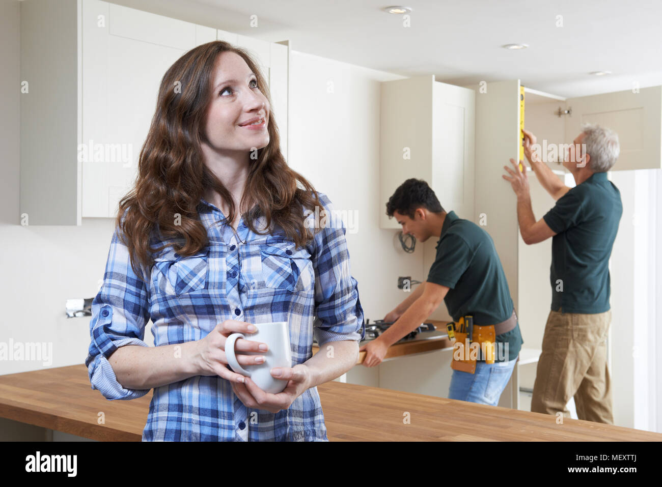 Woman Having New Kitchen Fitted Drinking Cup Of Coffee Stock Photo