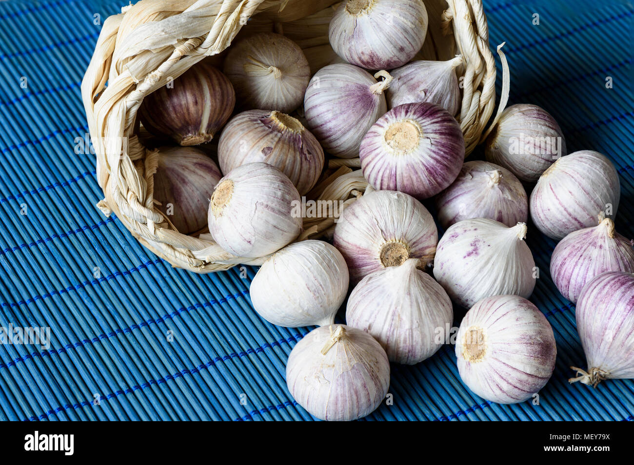 Garlic in a basket and on a mat close up Stock Photo - Alamy