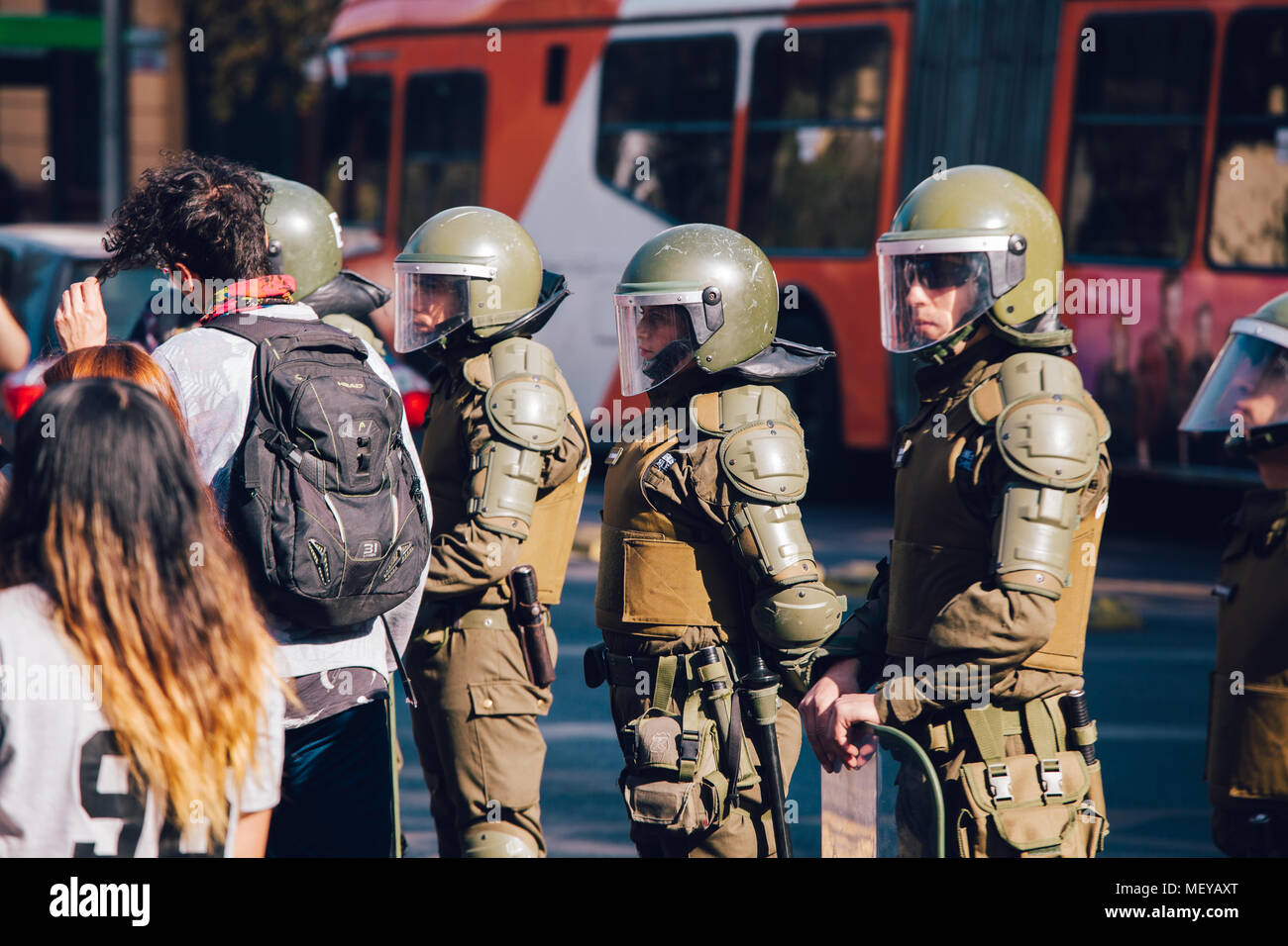Santiago, Chile - April 19, 2018: A line of Chilean riot police observing protesters during a demonstration in Santiago's Downtown, Chile. Protesters  Stock Photo