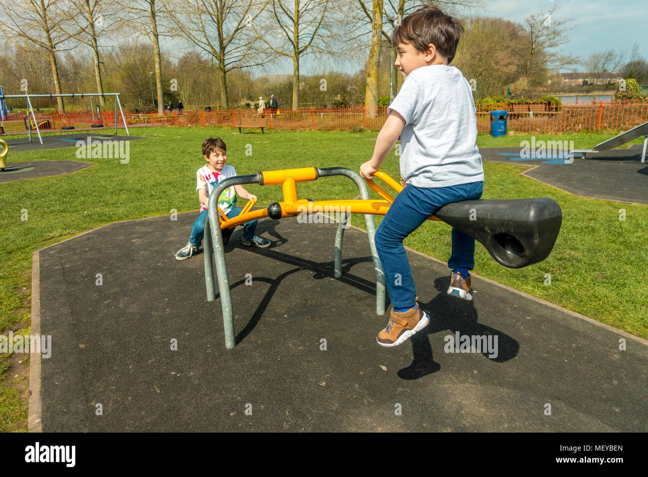 Brothers playing on a seesaw in a children's playground in the village