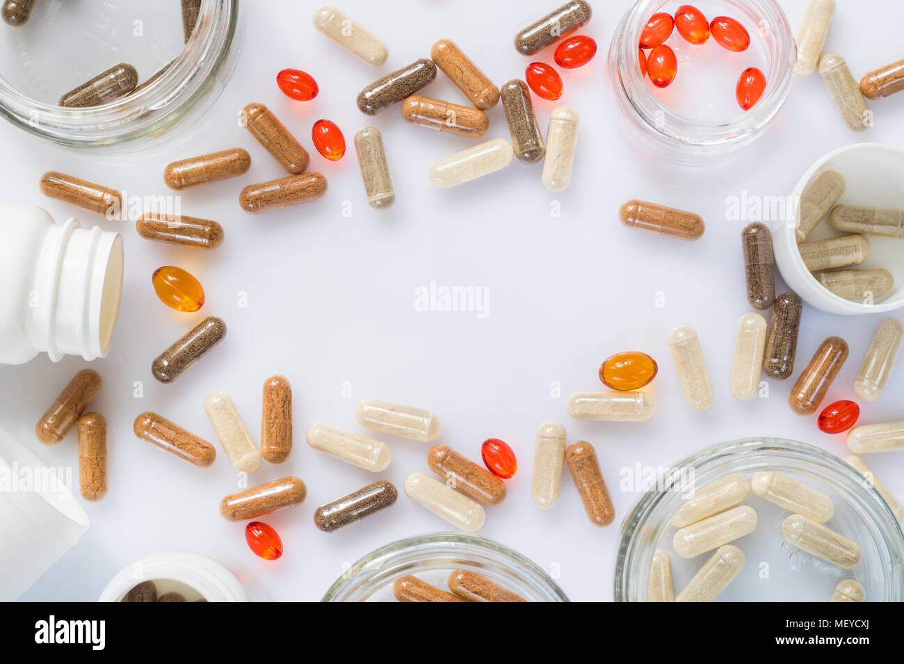 Different medicinal capsule, pills and jars on a light surface Stock Photo