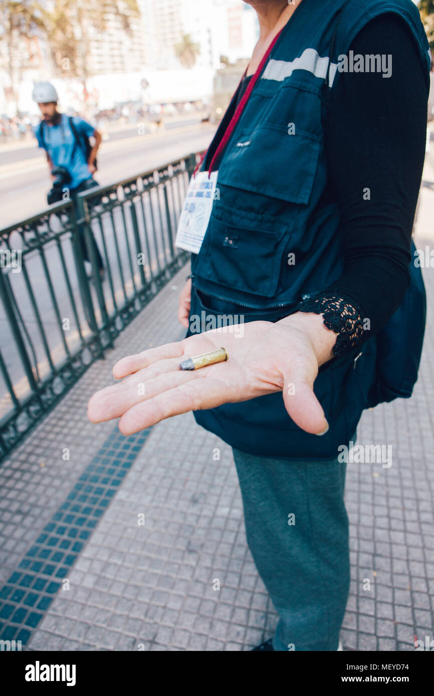 Santiago, Chile - April 19, 2018: Representative of 'Human Rights' shows a bullet found in the road during the march against the profit in education i Stock Photo