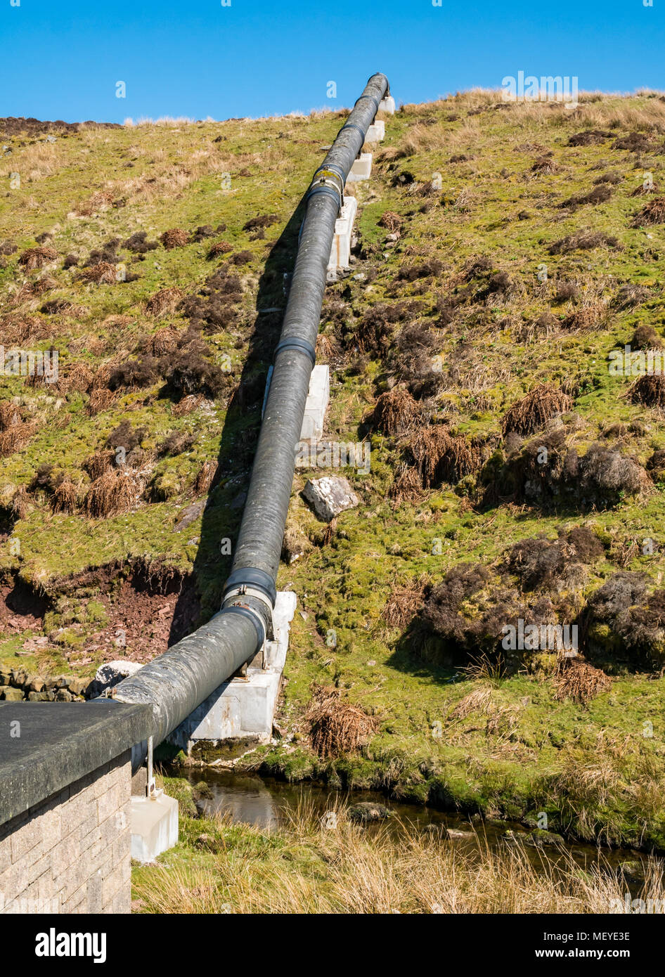 Water pipes along the Medwin Water valley, rising up a hill, Scottish