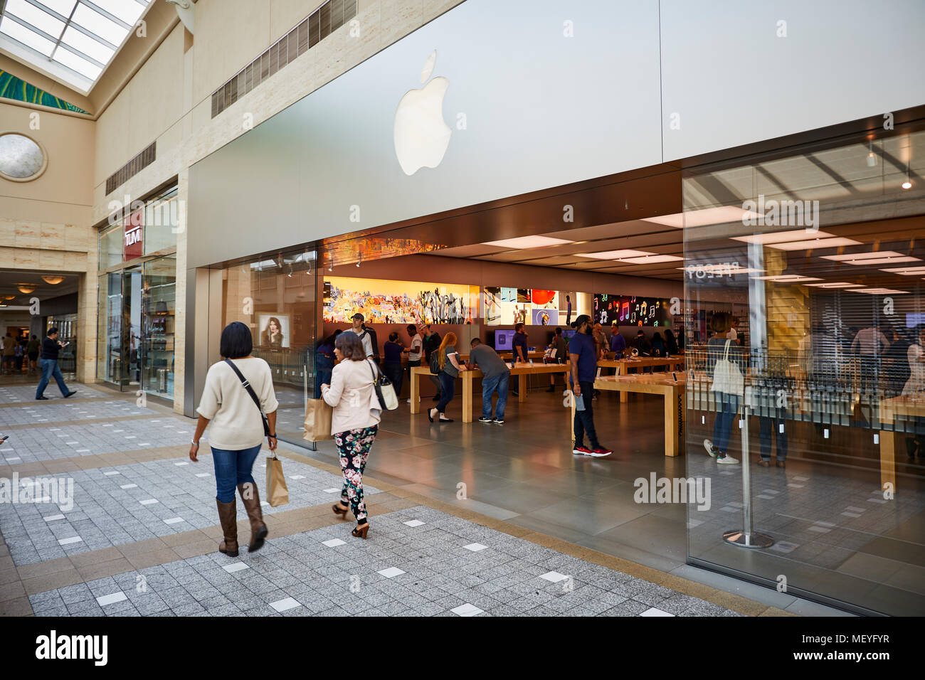 Apple Store signage at Lenox Square in the Buckhead area of Atlanta,  Georgia, with metallic Apple logo on glass reflecting a nearby skyscraper.  (USA Stock Photo - Alamy