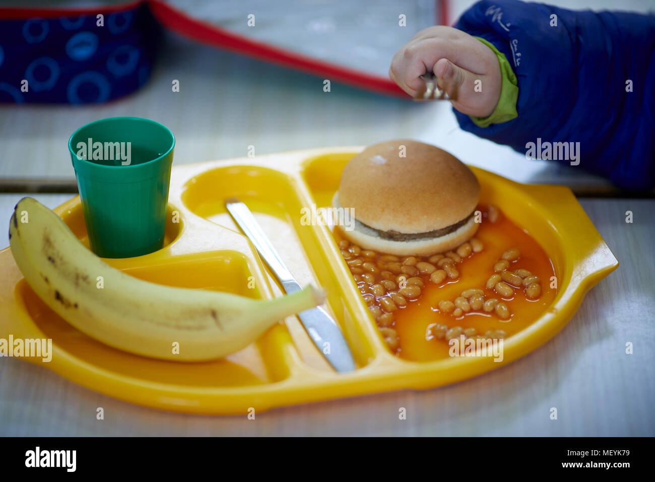 A school dinner meal tray with burger, beans, fruit banana and drink Stock Photo