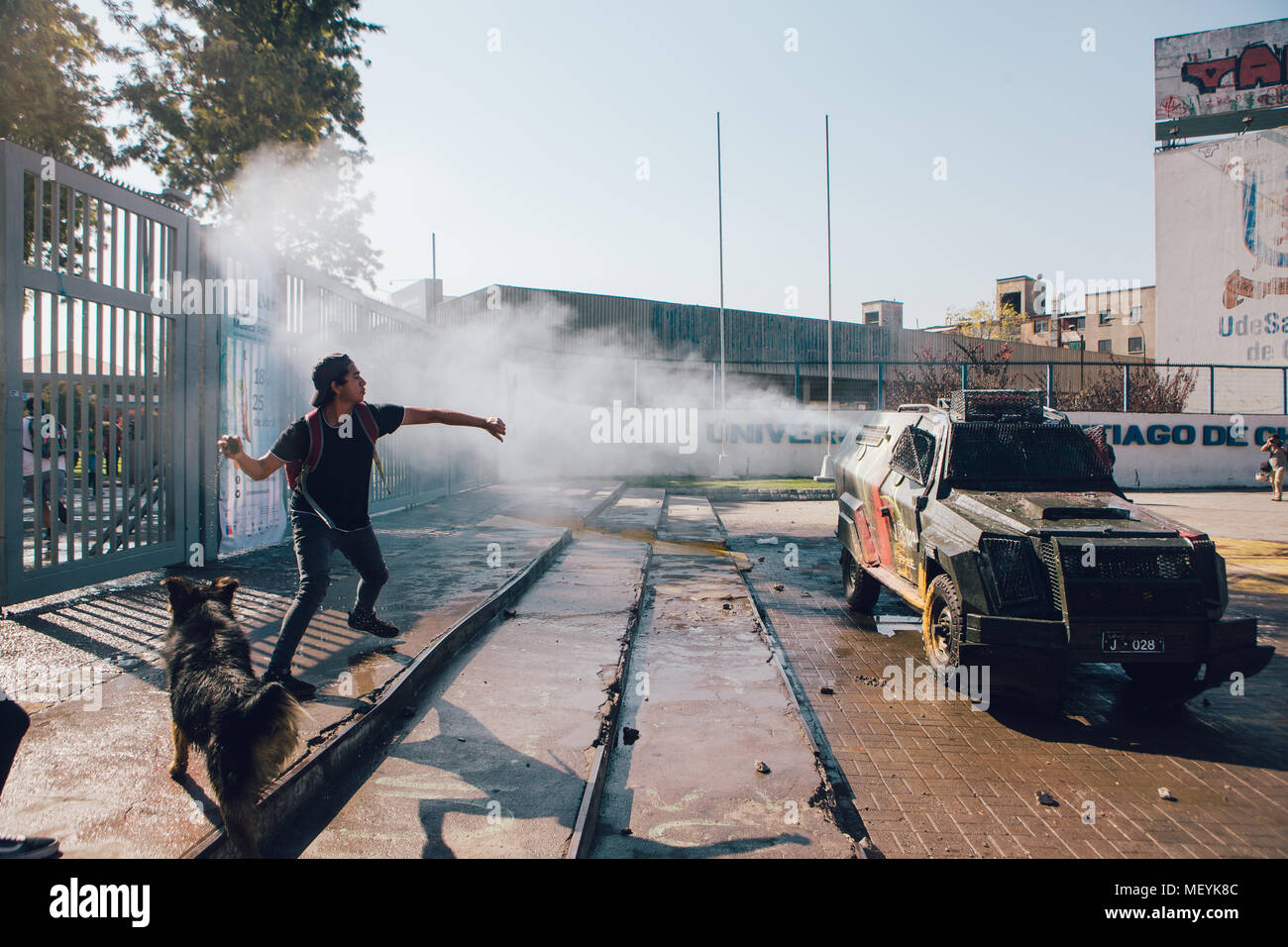 Santiago, Chile - April 19, 2018: Student stoned police vehicle at the entrance of the University of Santiago during a demonstration demanding an end  Stock Photo