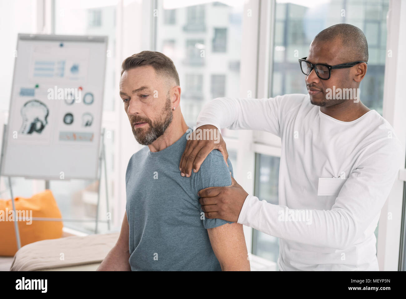 Smart nice man touching his patients shoulder Stock Photo