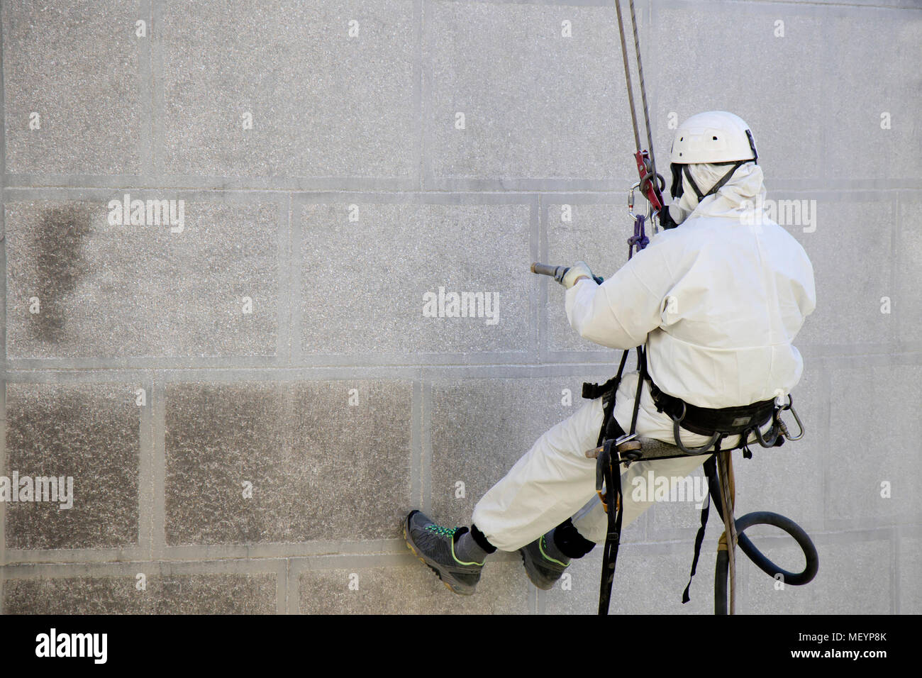 Rope access facase maintenance; A worker wearing a protective gear