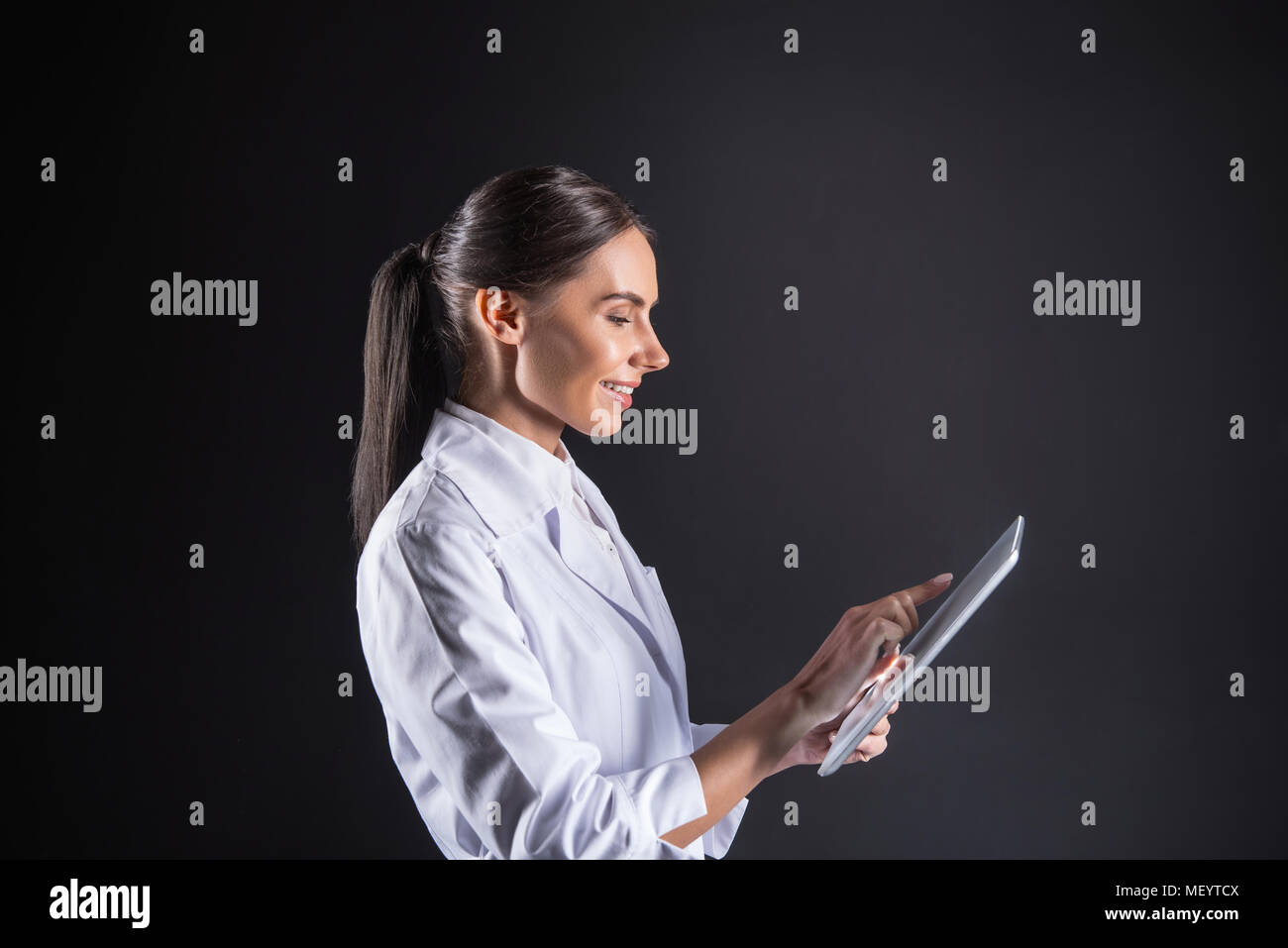 Nice delighted scientist using a digital device Stock Photo