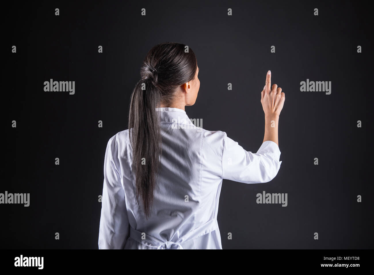 Nice intelligent scientist pressing her finger to the screen Stock Photo