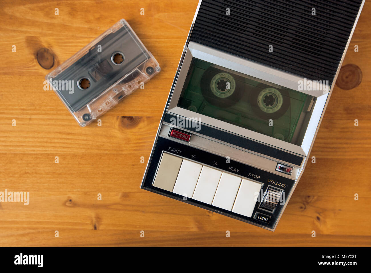 Audio cassette tape rolling in vintage player on the desk, top view