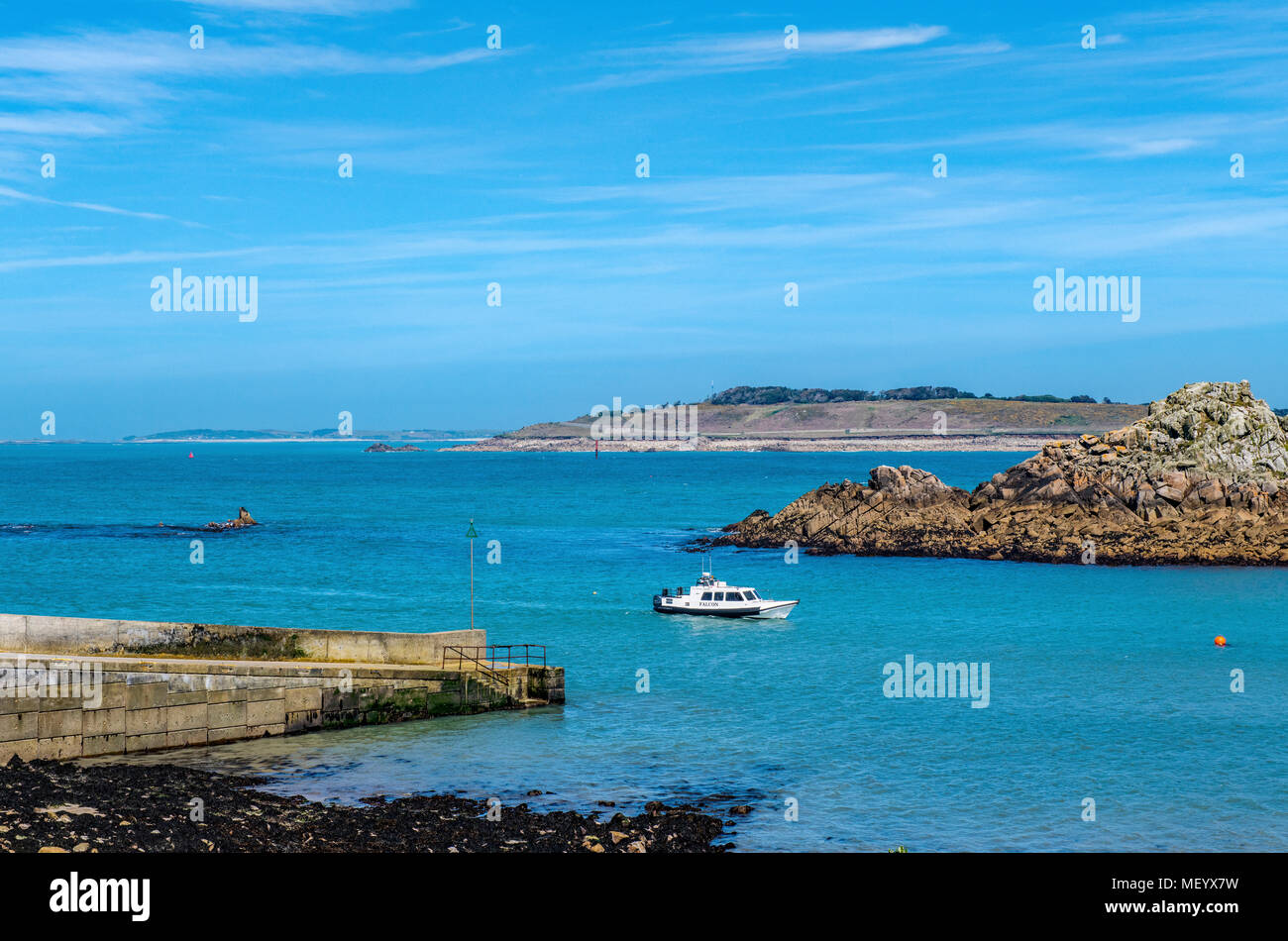 Boat coming in to St Agnes Quay on the Isles of Scilly on a sunny Spring Day Stock Photo