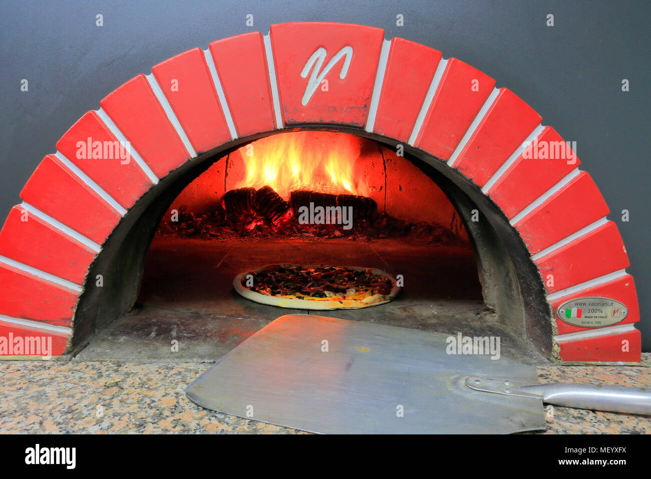 Cheese and Pepperoni Sausage Pizza in a traditional pizza oven Stock Photo