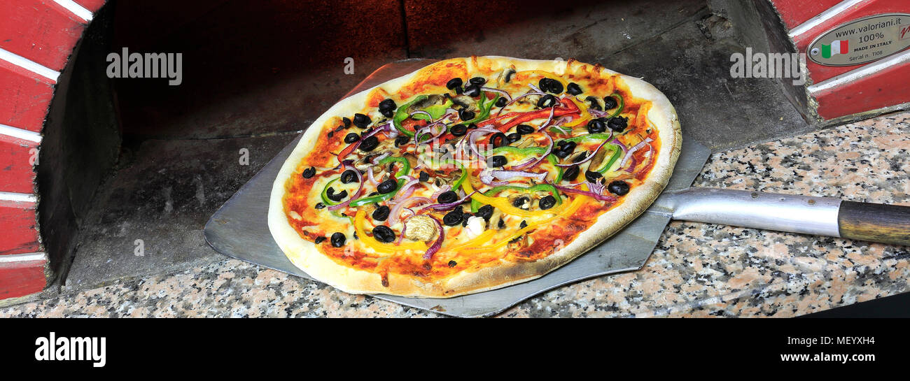 Cheese and Pepperoni Sausage Pizza in a traditional pizza oven Stock Photo