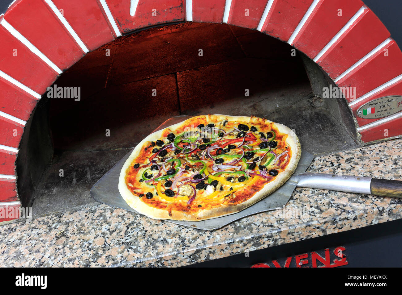 Cheese and Pepperoni Sausage Pizza in a traditional pizza oven Stock Photo