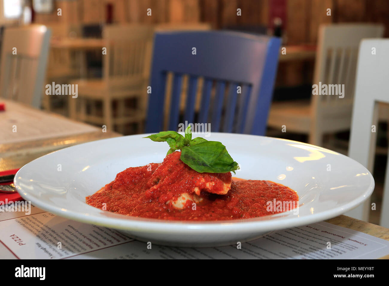 Sea Bass fillet in a cherry tomato sauce in a restaurant setting Stock Photo