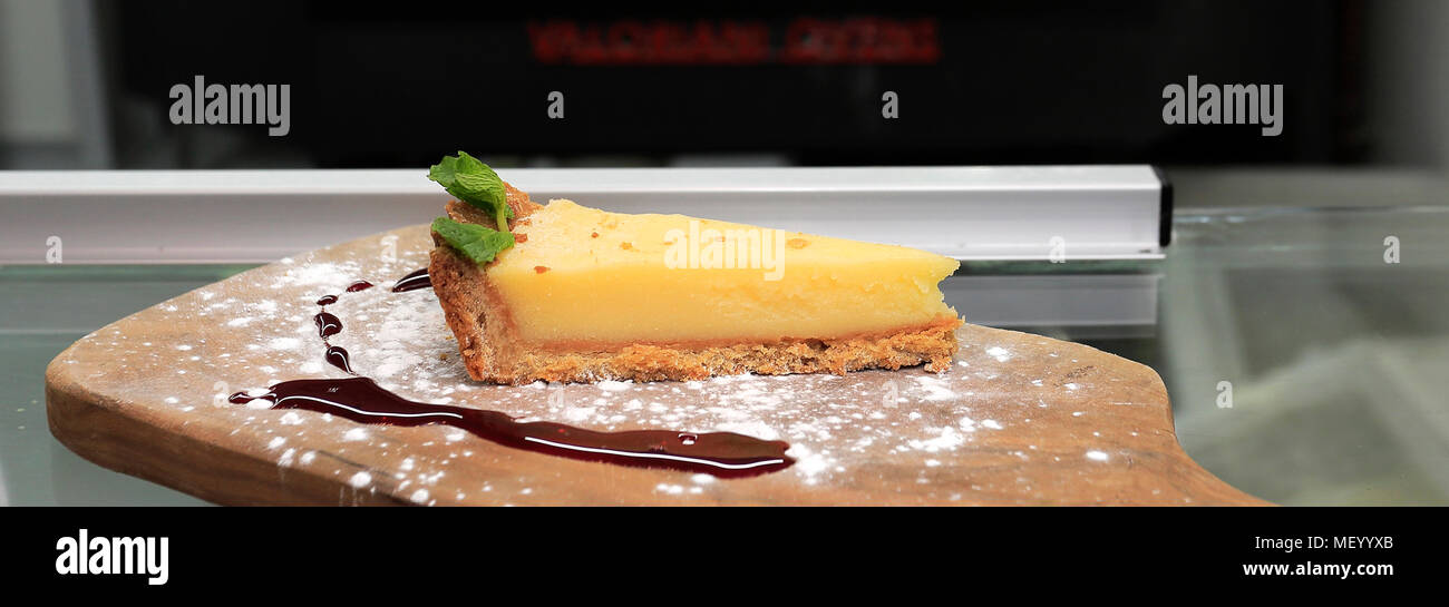 Slice of Lemon Cheesecake, in a restaurant setting Stock Photo