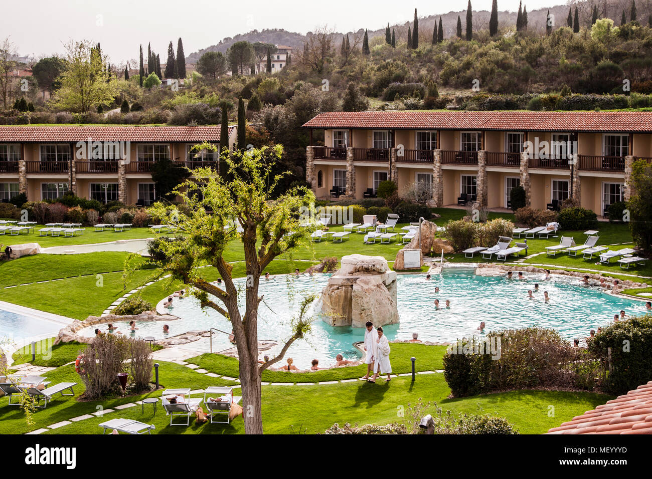 Hotel Adler Thermae, Bagno Vignoni, Tuscany with thermal pool, Tuscany, Val d'orcia Italy, UNESCO World Heritage. Both very tempting: the thermal world with several outdoor pools and beyond the harmoniously inserted wings with the guest rooms, the hills and cypress landscape of the Val d'Orcia. Stock Photo
