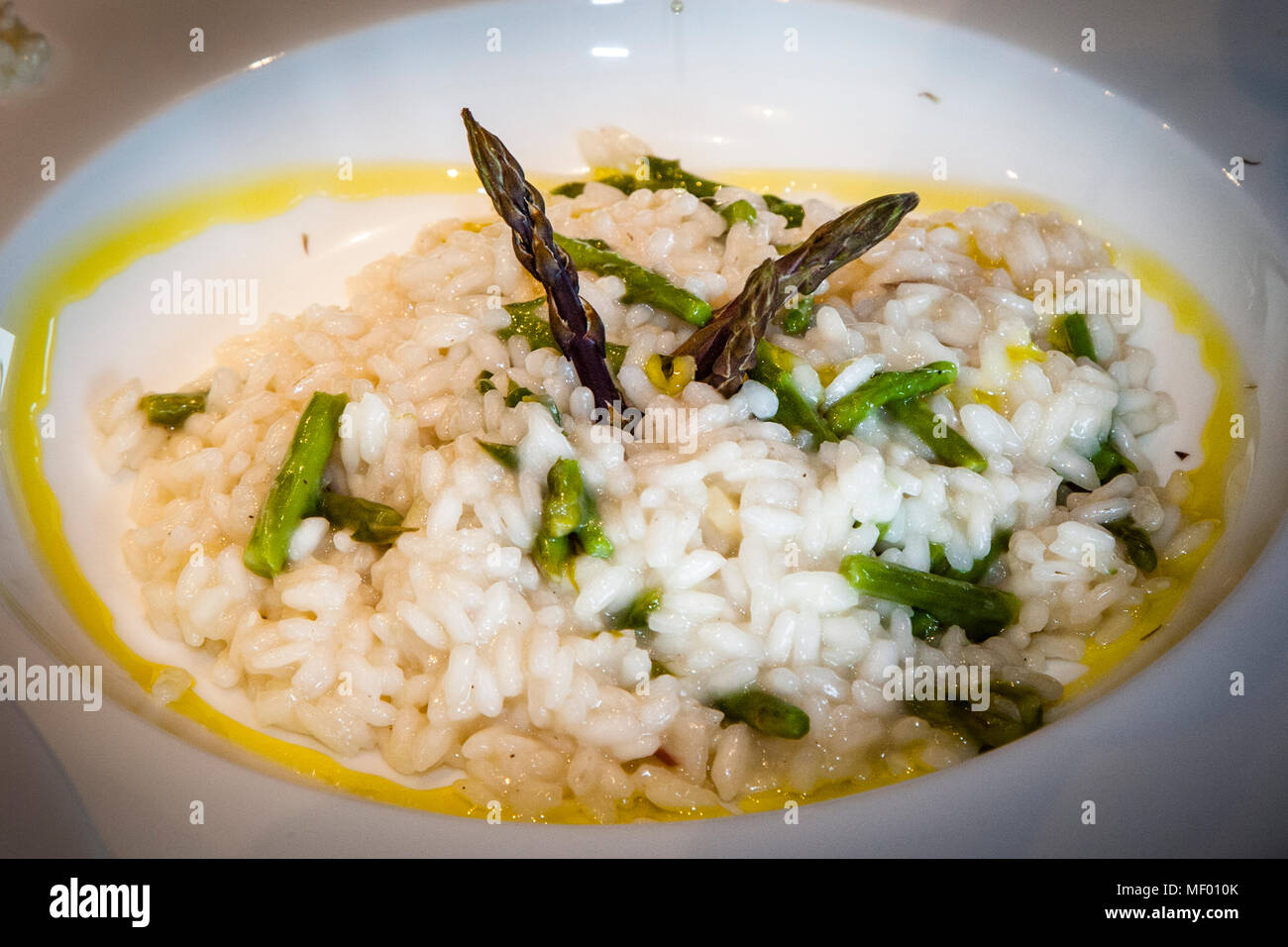 Foraging and preparation of wild asparagus. Asparagus risotto with wild asparagus of Tuscany, a delicacy only for a short time in spring Stock Photo