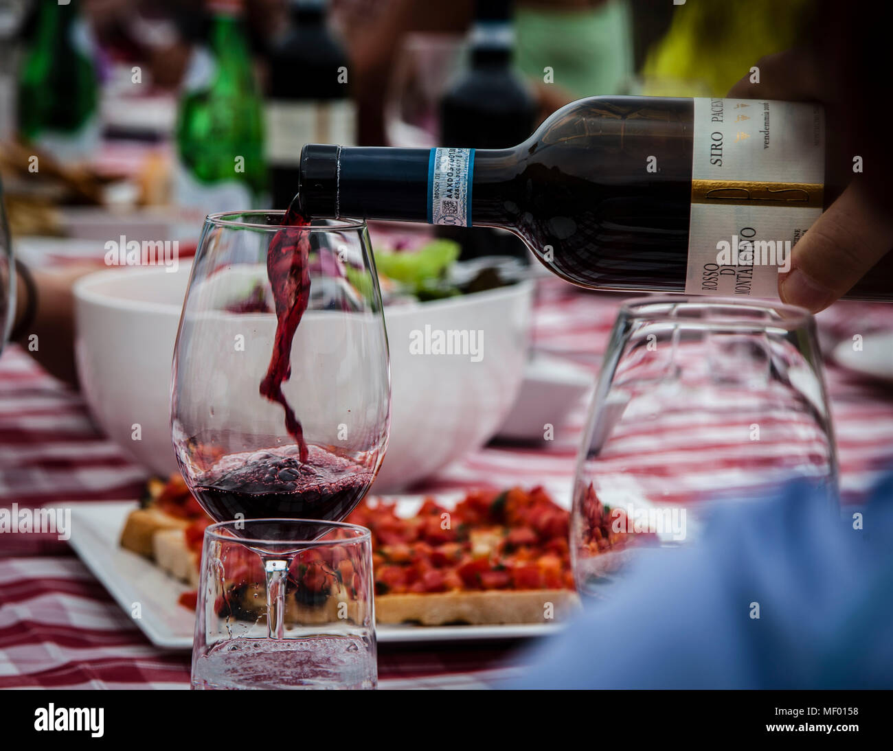 Summer picnic in Tuscany, close-up of a bottle of red wine poured into a glas, wine from Montalcino, famous wine maker Stock Photo