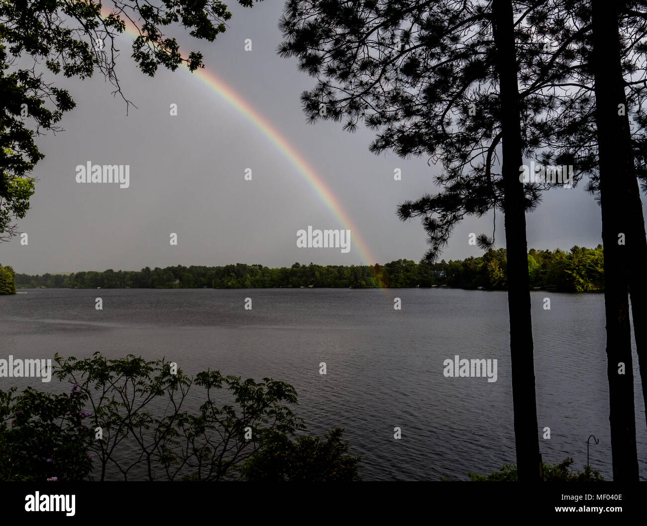 Rainbow reaches across the lake after a rain Stock Photo - Alamy
