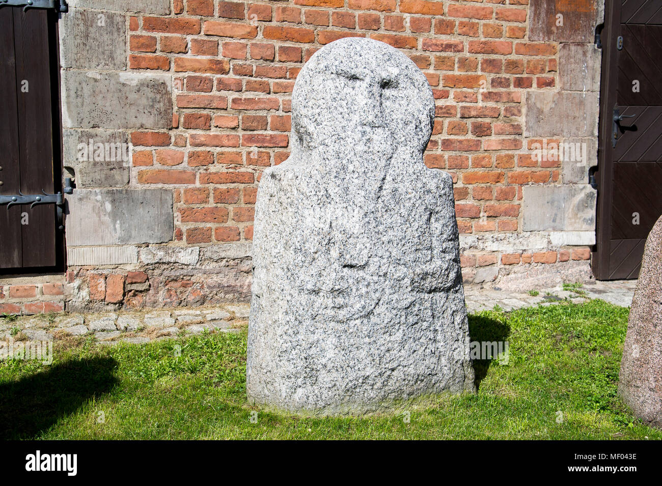 Anthropomorphic stone stelae in front of Brama Mariacka (St Mary's Gate, currently the Archaeological Museum) on Dlugie Pobrzeze (Motlawa River Embank Stock Photo