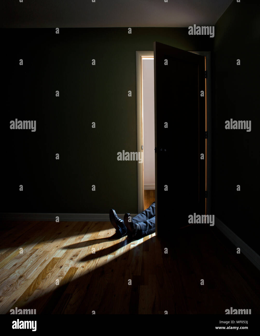 Person laying in a Dark Doorway Stock Photo